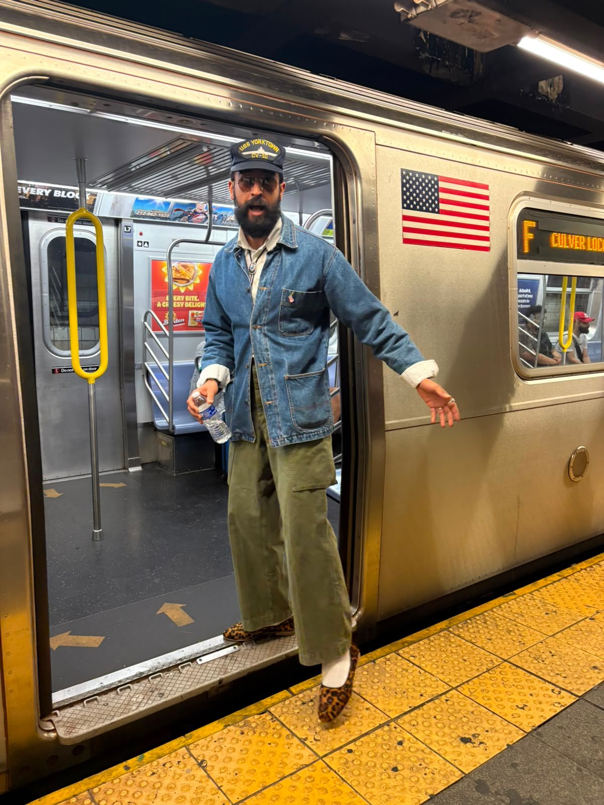 Shed Stoune founder wearing the original leopard loafers beside a New York subway train