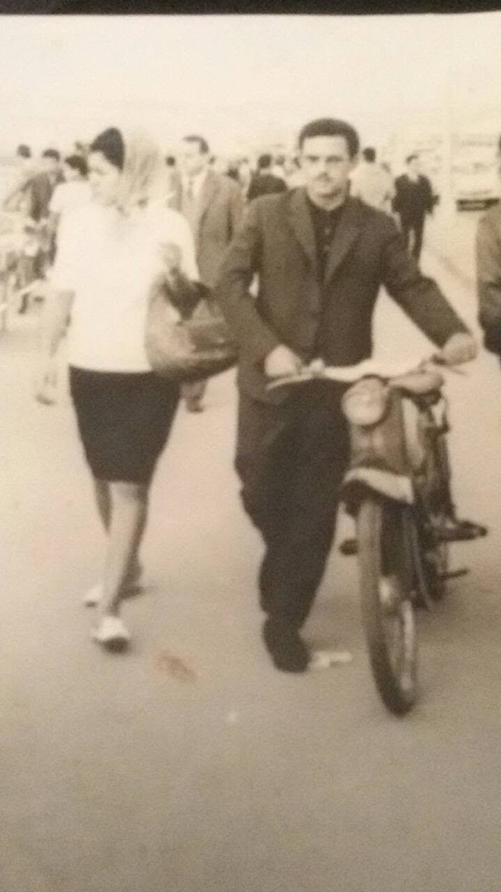 Family photograph from Casablanca showing a woman and man walking beside a motorcycle